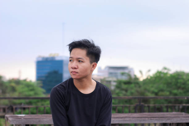 istock Young men sitting waiting enjoying at city park 1345560105