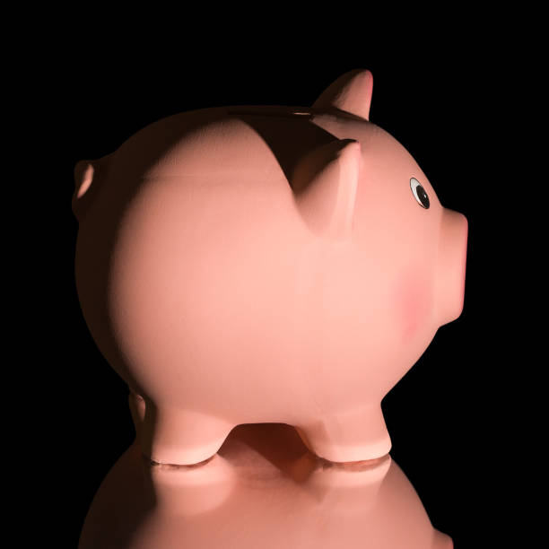 istock Pink ceramic piggy bank, isolated on blackbackground 1345562885