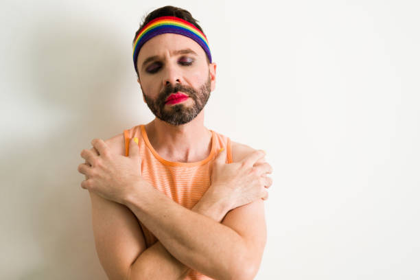 Embracing gender identity and promoting self love. Attractive gay man hugging himself with his eyes closed