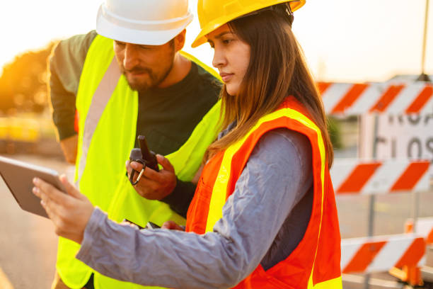istock Digital Tablet Communication in the Field Hispanic Workers Setting Barriers and Directing Traffic Street Road and Highway Construction Photo Series 1345564072