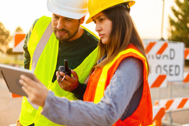 istock Digital Tablet Communication in the Field Hispanic Workers Setting Barriers and Directing Traffic Street Road and Highway Construction Photo Series 1345564208