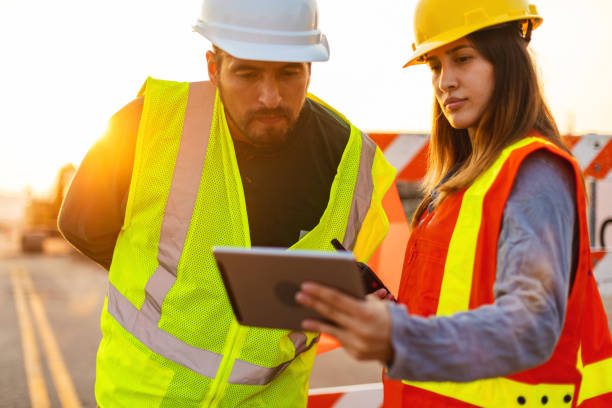 istock Digital Tablet Communication in the Field Hispanic Workers Setting Barriers and Directing Traffic Street Road and Highway Construction Photo Series 1345564618
