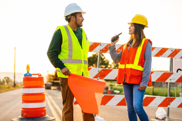 istock Hispanic Workers Setting Barriers and Directing Traffic Street Road and Highway Construction Photo Series 1345564620