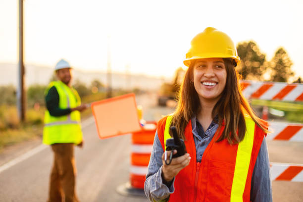 istock Communication in the Field Hispanic Workers Setting Barriers and Directing Traffic Street Road and Highway Construction Photo Series 1345564643