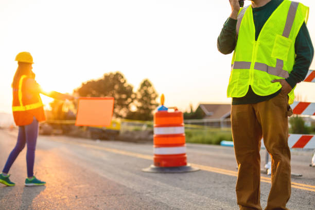 istock Communication Portrait Hispanic Workers Setting Barriers and Directing Traffic Street Road and Highway Construction Photo Series 1345564680
