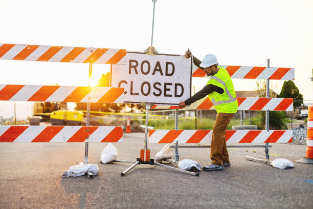 hispanische arbeiter, die barrieren errichten und den straßenstraßen- und autobahnbau leiten fotoserie - construction safety mid adult men road construction stock-fotos und bilder