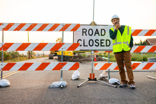 istock Hispanic Workers Setting Barriers and Directing Traffic Street Road and Highway Construction Photo Series 1345564699