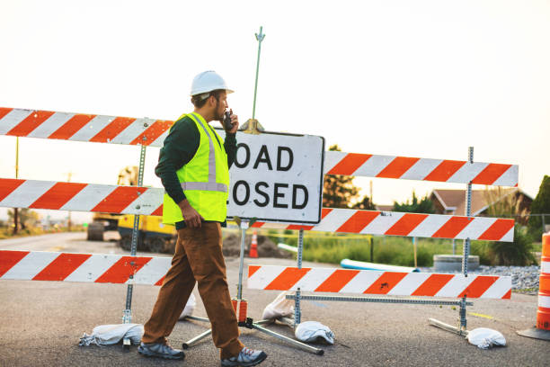 istock Hispanic Workers Setting Barriers and Directing Traffic Street Road and Highway Construction Photo Series 1345564723