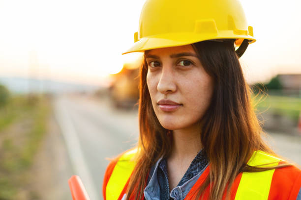 istock Authoritative Close-up Portrait of Hispanic Workers Setting Barriers and Directing Traffic Street Road and Highway Construction Photo Series 1345564983