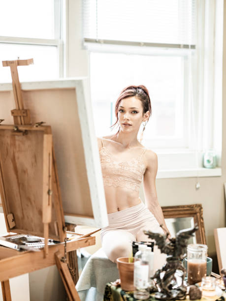 istock Young Caucasian woman painting in studio 1345570656
