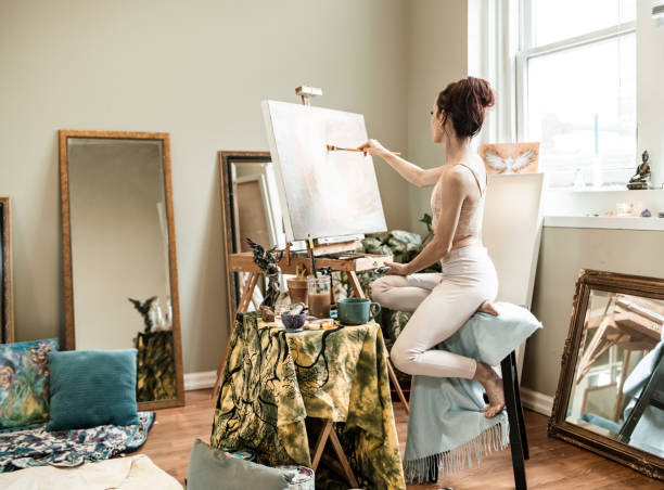 istock Young Caucasian woman painting in studio 1345570771
