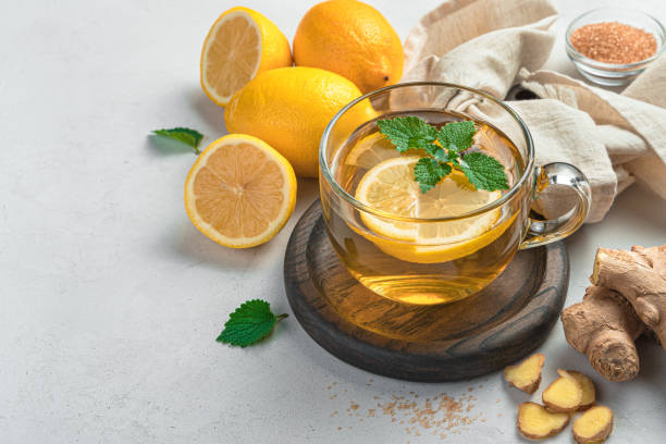 istock Healthy tea with lemon and ginger in a transparent cup on a gray background 1345575029