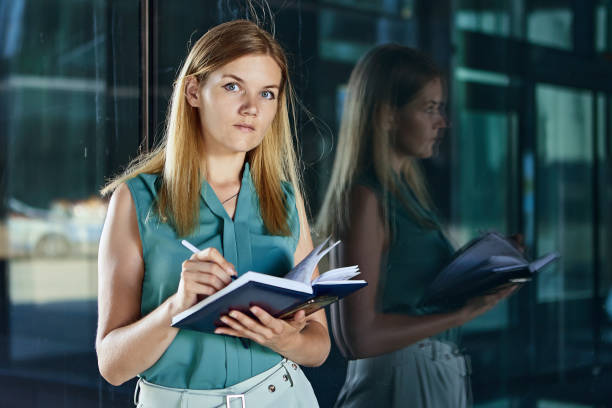 istock Female manager writes notes near business center in notebook. 1345578117