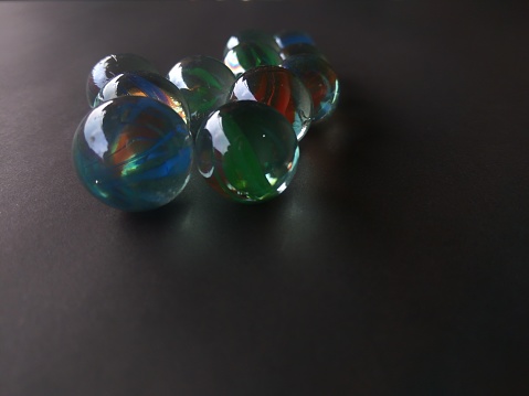 marbles made of glass, green, blue and red on a black background