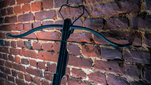 istock A modern compound crossbow handgun on the red brick wall background. Old weapon concept. 1345579555