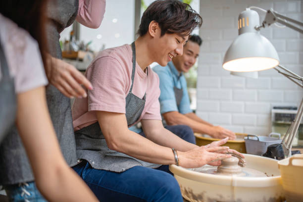 istock Chinese Craftspeople Molding Shapes on Pottery Wheel 1345581866