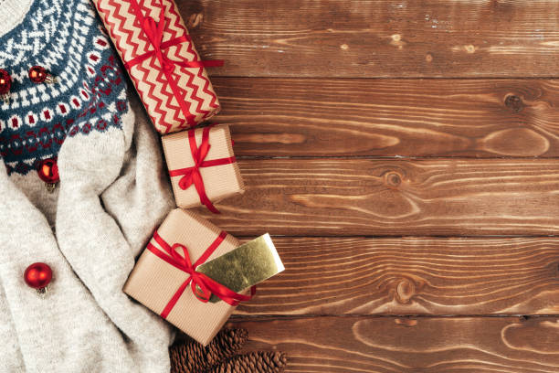 istock Warm sweater and Christmas gift on wooden background 1345599477