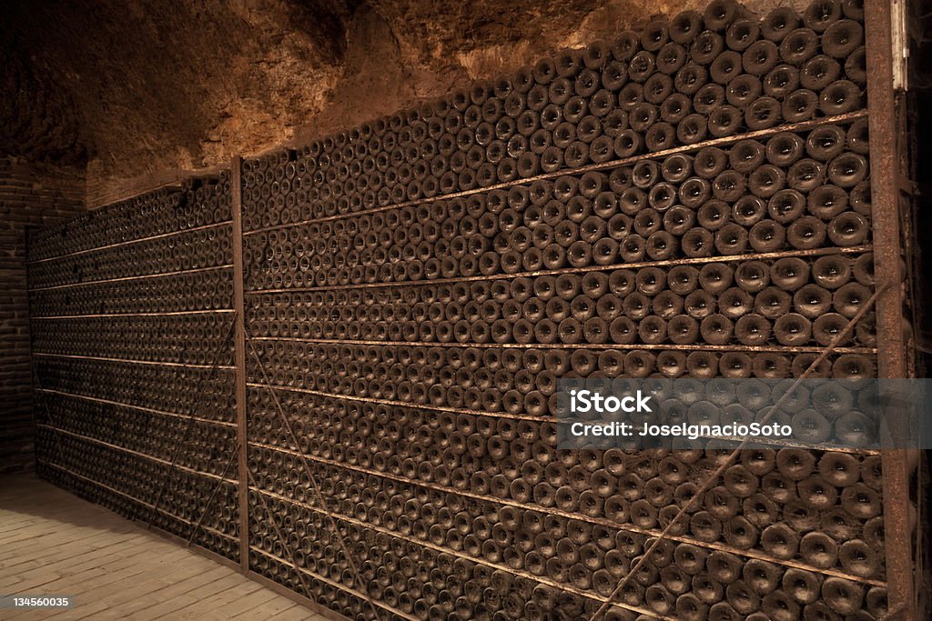 Viejo y sucio botellas de vinos en una bodega de antigüedad de apilado - Foto de stock de Bodega - Almacén libre de derechos