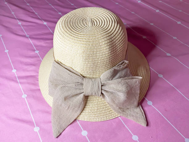 a knitted hat with a beautiful cloth ribbon that a woman usually wears when traveling or to the beach where the weather is so hot a knitted hat with a beautiful cloth ribbon that a woman usually wears when traveling or to the beach where the weather is so hot straw photos stock pictures, royalty-free photos & images