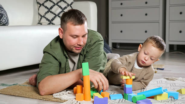 istock Father and son build tower using colorful wooden blocks 1345604722
