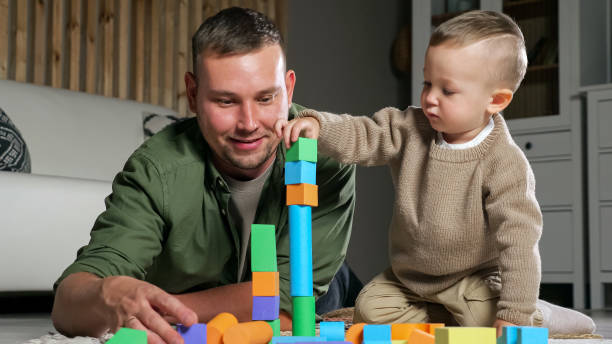 istock Father and son build tower using colorful wooden blocks 1345604729