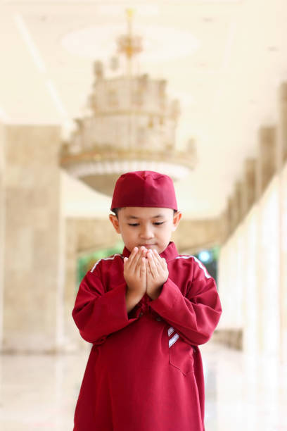 istock Asian Muslim boy at mosque praying 1345605317