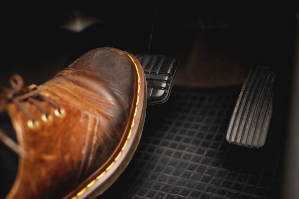 man stepping on car brake to slow down, stop the car both normal and abruptly - travão imagens e fotografias de stock