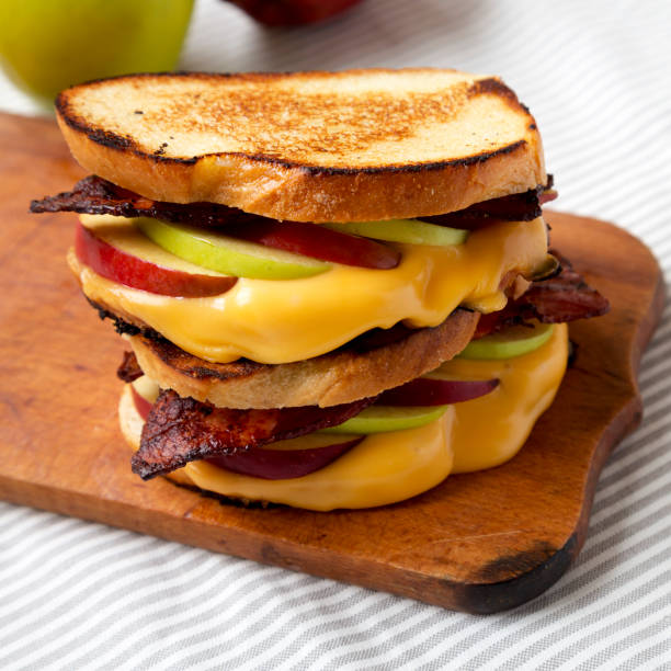 istock Homemade Bacon Apple Grilled Cheese on a rustic wooden board, side view. Close-up. 1345612775