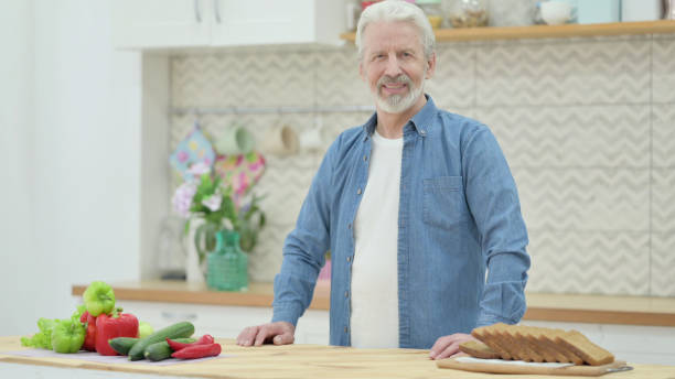 istock Old Man Shaking Head as Yes Sign while in Kitchen 1345613779