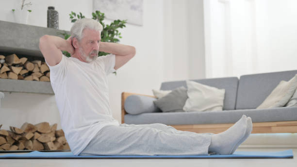 istock Old Man doing Stretches on Excercise Mat at Home 1345613863
