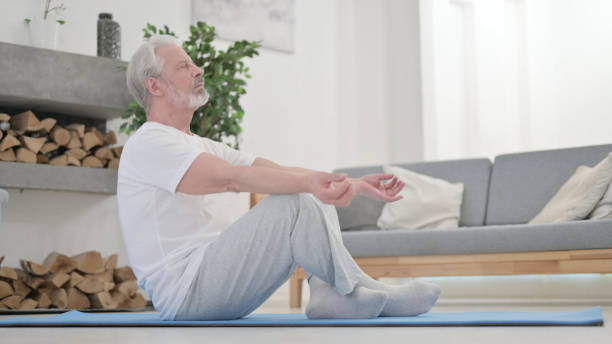 istock Old Man Meditating on Excercise Mat at Home 1345613965