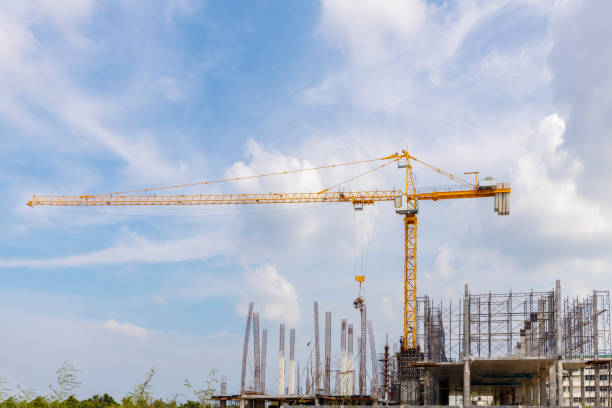 istock Working at height equipment with bucket liquid concrete container. Construction worker working on a high building. Crane lifting Cement mixer machine to  building. Crane lift concrete mixer container 1345615016