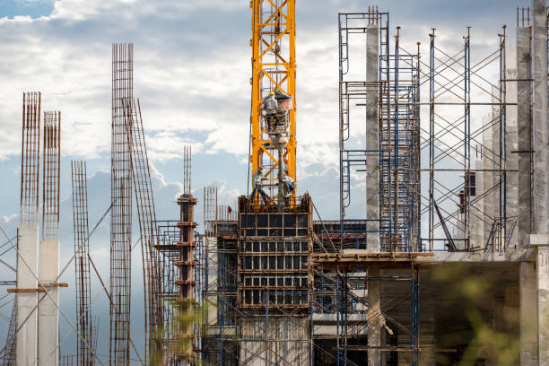 istock Working at height equipment with bucket liquid concrete container. Construction worker working on a high building. Crane lifting Cement mixer machine to  building. Crane lift concrete mixer container 1345615193