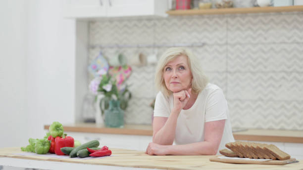 istock Pensive Old Woman Thinking in Kitchen 1345615903