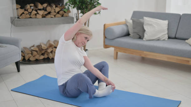 istock Old Woman doing Stretches on Excercise Mat at Home 1345615959