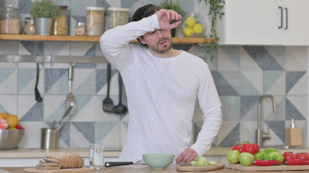 istock Healthy Young Man Feeling Tired while Cooking in Kitchen 1345619150