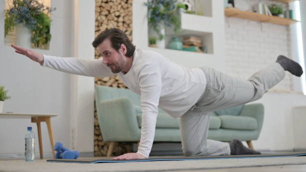 istock Young Man Stretching on Excercise Mat at home 1345619199