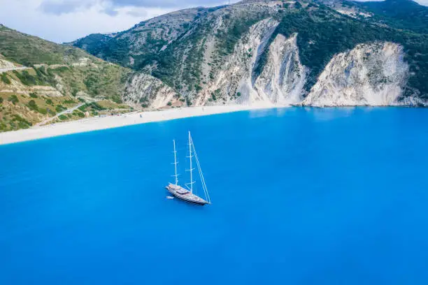 Aerial view of Luxury Sail Yacht in Myrtos beach with blue bay on Kefalonia Island, Greece.