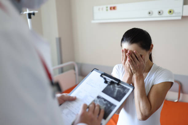 doctor holding documents in front of crying patient in clinic - mental health depression illness healthy lifestyle imagens e fotografias de stock