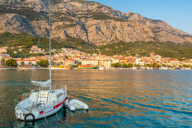 panorama miasta makarska, chorwacja podczas zachodu słońca. widok z małymi łodziami i górami biokovo w tle. letnia pogoda, miękkie ciepłe kolory. - makarska riviera zdjęcia i obrazy z banku zdjęć