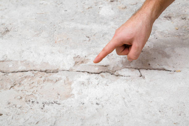 Young adult man hand finger pointing to cracked concrete floor. Building problem and solution concept. Closeup. Young adult man hand finger pointing to cracked concrete floor. Building problem and solution concept. Closeup. sign human hand pointing manual worker stock pictures, royalty-free photos & images