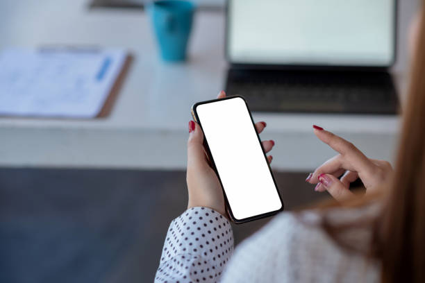 istock Mock up. image of woman holding mobile phone with blank white screen. 1345630037
