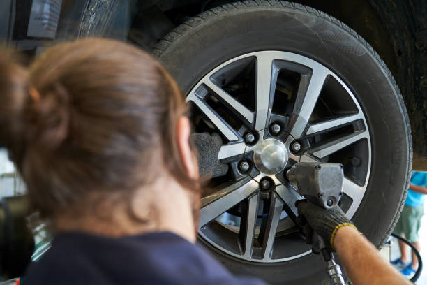 istock Mechanic male use air gun try to remove nut wheel for replace ti 1345630488