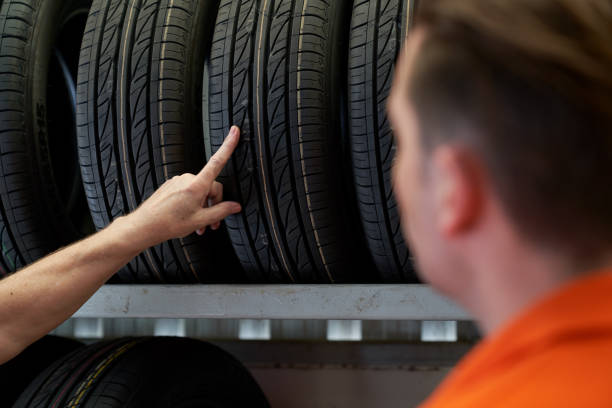 hand des kundenpunkts wählen sie reifen für auto mit personal in reifen - tire auto repair shop part of vehicle stack stock-fotos und bilder