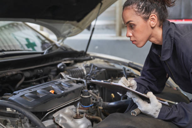 técnico femenino lista de verificación para el mantenimiento a en el garaje del coche se - adult manual worker automobile industry transportation fotografías e imágenes de stock