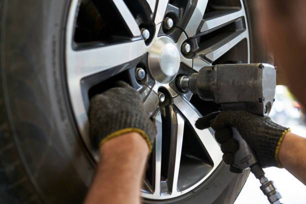 istock Mechanic male use air gun try to remove nut wheel for replace ti 1345632215