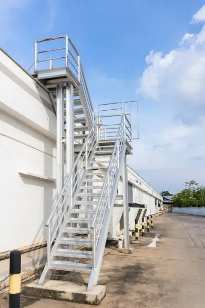 Steel railing roof stairs. Metal staircase to the roof of a modern building. Stairwell fire or emergency exit on wall of building