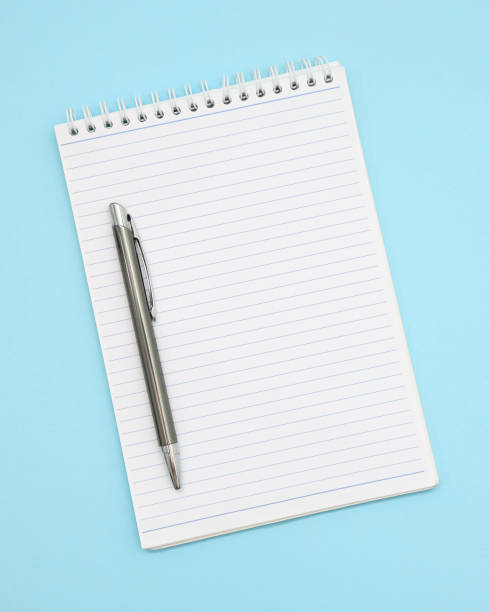 istock Top view of blank spiral notes with pen isolated on pastel blue background for mockup 1345633497