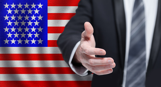 USA business, politics, cooperation and travel concept. Hand on flag of USA background.