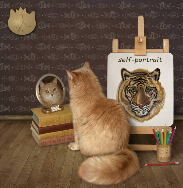 istock Cat ginger looks in mirror near its self-portrait 1345637876